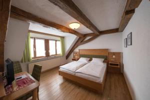 a bedroom with a bed and a desk and a window at Der Adler in Lauchringen