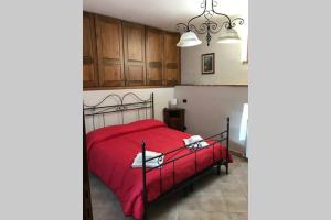 een slaapkamer met een rood bed en houten kasten bij APPARTAMENTI DOLCETURISMO FONTECAIME...RELAX... in Bevagna