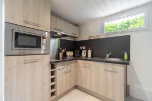 a kitchen with a microwave and a sink at Résidence confortable au calme quartier St Marceau in Orléans