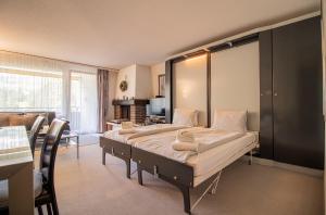 a bedroom with a large bed and a living room at Rothornblick 39 by Arosa Holiday in Arosa