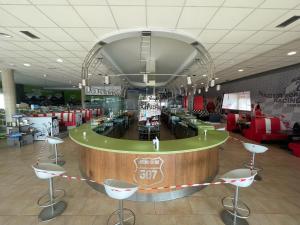 a restaurant with a bar with stools in the middle at Area 507 in Outeiro de Rei