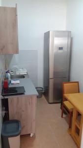 a kitchen with a stainless steel refrigerator and a table at Apartman PETI PUK in Valjevo