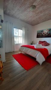 a bedroom with a large bed with a red rug at Ons Fontein in Langebaan