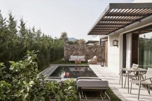 une arrière-cour avec une piscine, une table et des chaises dans l'établissement The Olivar Suites, à Mesongi