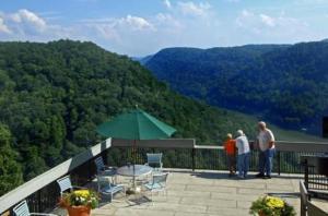 a group of people standing on a balcony looking at the mountains at Hawks Nest Lodge in Ansted