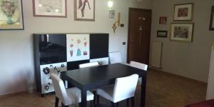 une salle à manger avec une table noire et des chaises blanches dans l'établissement La Casetta sul Camposcuola, à Teramo