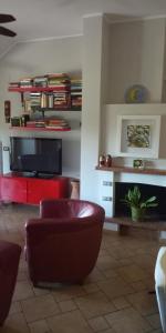 een woonkamer met een tv en een stoel en een bank bij La Casetta sul Camposcuola in Teramo