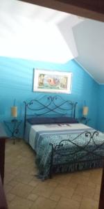 een slaapkamer met een bed in een blauwe muur bij La Casetta sul Camposcuola in Teramo