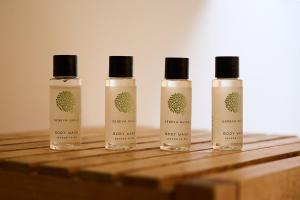 three bottles of soap sitting on a wooden table at Vert Lodge Chamonix in Chamonix-Mont-Blanc