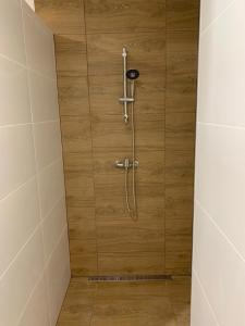 eine Dusche mit einer Holzwand im Bad in der Unterkunft Tokajský domček in Malá Tŕňa
