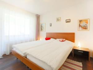 sypialnia z dużym łóżkiem z czerwonymi poduszkami w obiekcie Apartment Roc by Interhome w mieście Zermatt
