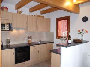 a kitchen with wooden cabinets and black counter tops at Chalet Escapade by Interhome in Ovronnaz