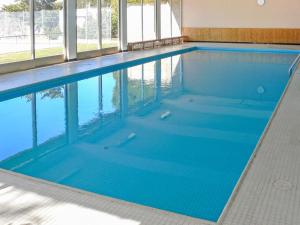 ein großer Pool mit blauem Wasser in einem Gebäude in der Unterkunft Apartment Cransalpin-1 by Interhome in Vermala