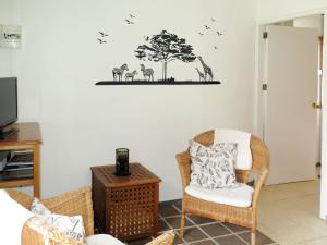 a living room with a chair and giraffe decal on the wall at Apartment Las Cuevecitas - CND110 by Interhome in Icoro