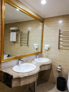 a bathroom with two sinks and a large mirror at Kartmazovo Country Club in Kartmazovo