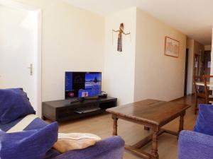 a living room with a table and a tv at Apartment Terrasse Des Alpes 814 by Interhome in Vermala