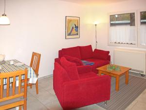 SchwarzにあるHoliday Home Ludwig by Interhomeのリビングルーム(赤いソファ、テーブル付)