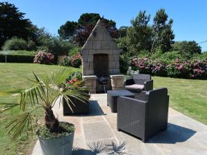 - un jardin avec deux chaises et une cheminée en pierre dans l'établissement Holiday Home La Rotonde by Interhome, à Port-Blanc