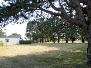 um campo com uma árvore e um edifício branco em Holiday Home Les mielles - SYL400 by Interhome em Denneville-Plage