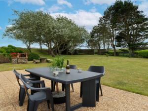 a black table with chairs and a bottle of wine at Holiday Home Ty Coz by Interhome in Guissény