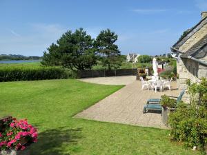 a garden with chairs and a table and a house at Holiday Home Ty Coz by Interhome in Guissény