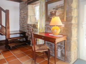 une table avec une lampe à côté d'un mur en pierre dans l'établissement Holiday Home Le Manoir by Interhome, à Pont-lʼAbbé