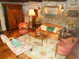 a living room with a couch and chairs and a table at Holiday Home Le Manoir by Interhome in Pont-lʼAbbé