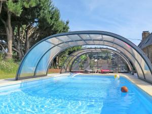 uma piscina com uma ponte de metal sobre ela em Holiday Home Gîte Triskell - PML101 by Interhome em Ploumilliau