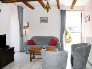 uma sala de estar com um sofá, cadeiras e uma mesa em Holiday Home Gîte Triskell - PML101 by Interhome em Ploumilliau