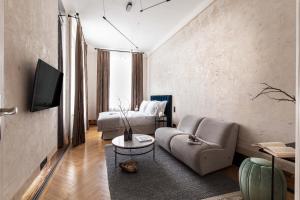 ein Wohnzimmer mit einem Sofa und einem TV in der Unterkunft Zola Hotel - Palais de Bohème Adults Only in Wien