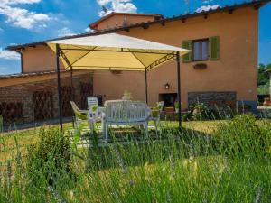 un tavolo e sedie sotto un ombrellone giallo di fronte a una casa di Apartment Azalea by Interhome a Pian di Scò