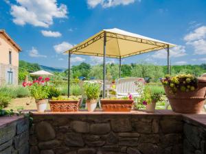 patio con piante in vaso e ombrellone giallo di Apartment Azalea by Interhome a Pian di Scò