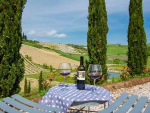 Aia MurataにあるHoliday Home Il Vallone by Interhomeのワイングラス2杯とワイン1本付きのテーブル