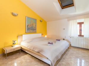 a bedroom with a bed and a yellow wall at Apartment Antonella & Napoletano-4 by Interhome in Umag