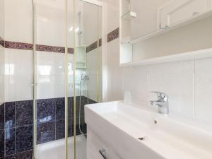 a white bathroom with a sink and a shower at Apartment Antonella & Napoletano-4 by Interhome in Umag
