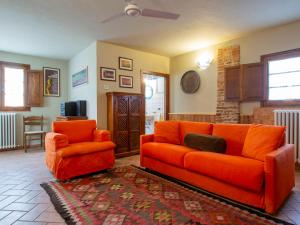 Aia MurataにあるHoliday Home Il Vallone by Interhomeのリビングルーム(オレンジ色のソファ、椅子付)