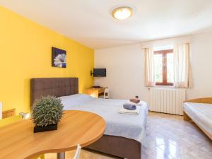 Schlafzimmer mit einem Bett und einem Tisch in der Unterkunft Apartment Antonella & Napoletano-1 by Interhome in Umag
