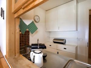 a small kitchen with white cabinets and a sink at Apartment Chesa Linaria by Interhome in Surlej