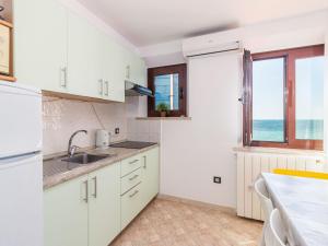 a kitchen with white cabinets and a view of the ocean at Apartment Antonella & Napoletano-3 by Interhome in Umag