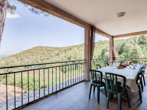 a dining room with a table and chairs on a balcony at Holiday Home A Mandria by Interhome in Ghisoni