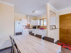 a kitchen with a wooden table and chairs at Holiday Home A Mandria by Interhome in Ghisoni