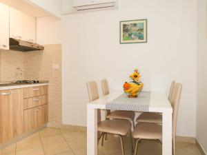 kuchnia ze stołem z krzesłami i wazonem w obiekcie Apartment Klaudija - RAC145 by Interhome w Rabacu