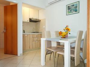 kuchnia i jadalnia ze stołem i krzesłami w obiekcie Apartment Klaudija - RAC145 by Interhome w Rabacu