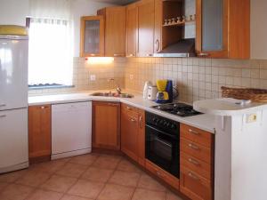 a kitchen with wooden cabinets and a stove top oven at Apartment Villa Ursa - PUL320 by Interhome in Pješčana Uvala