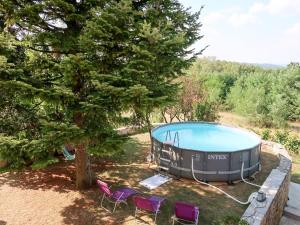 a house with a swimming pool and chairs next to a tree at Apartment Mirjana - LBN312-2 by Interhome in Ružići