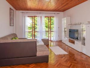 a living room with a couch and a television at Apartment Mirjana - LBN312-2 by Interhome in Ružići