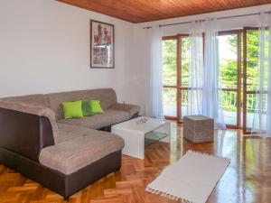 a living room with a couch and a table at Apartment Mirjana - LBN312-2 by Interhome in Ružići
