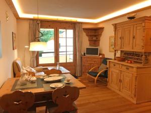 ein Wohnzimmer mit einem Tisch und einer Küche in der Unterkunft Apartment Chesa Alvetern 5 by Interhome in Sils Maria