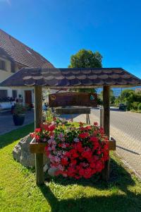 Eine Bank mit einem Haufen Blumen und einem Regenschirm. in der Unterkunft Apartment Arn's Ferienwohnung-1 in Wangenried  