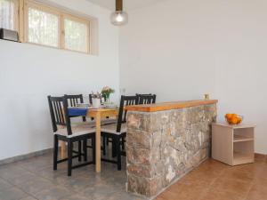 uma sala de jantar com uma mesa e cadeiras ao lado de uma parede de pedra em Apartment Starčević - NOV311 by Interhome em Novi Vinodolski